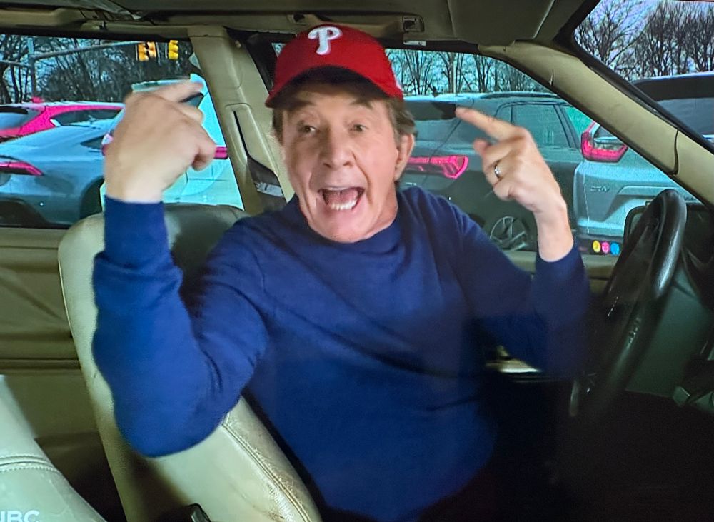 Martin Short pointing to his Phillies cap