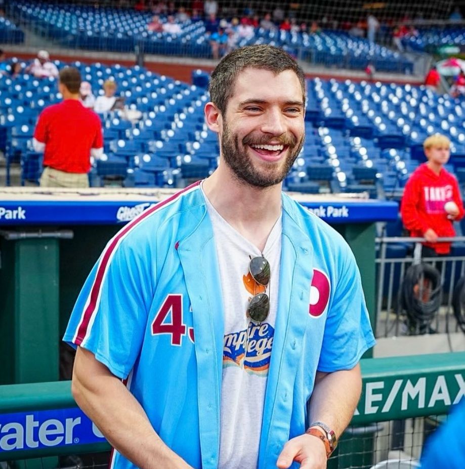 David Corenswet smiling ear to ear in a Phillies throwback blue jersey