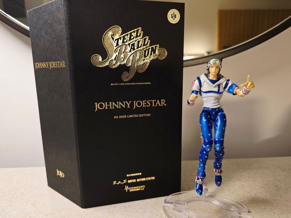 Photograph of the Medicos SAS Johnny Joestar Figure 【Limited Cystal Edition】 posing and the front of the box it comes in. 