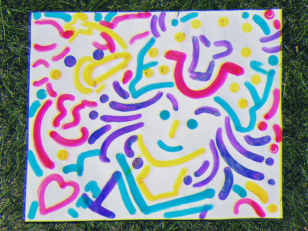 A piece of paper on grass that has teal, coral, yellow, and purple colored dots and streaks that resemble Johnny Joestar and Tusk Act 1. 
