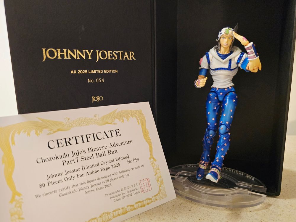 Photograph of the Medicos SAS Johnny Joestar Figure 【Limited Cystal Edition】 posing and the inside of the box it comes in, plus the certificate of authenticity. This particular figure is 54/80 ever made, and was a limited edition sold exclusively at Anime Expo 2025.