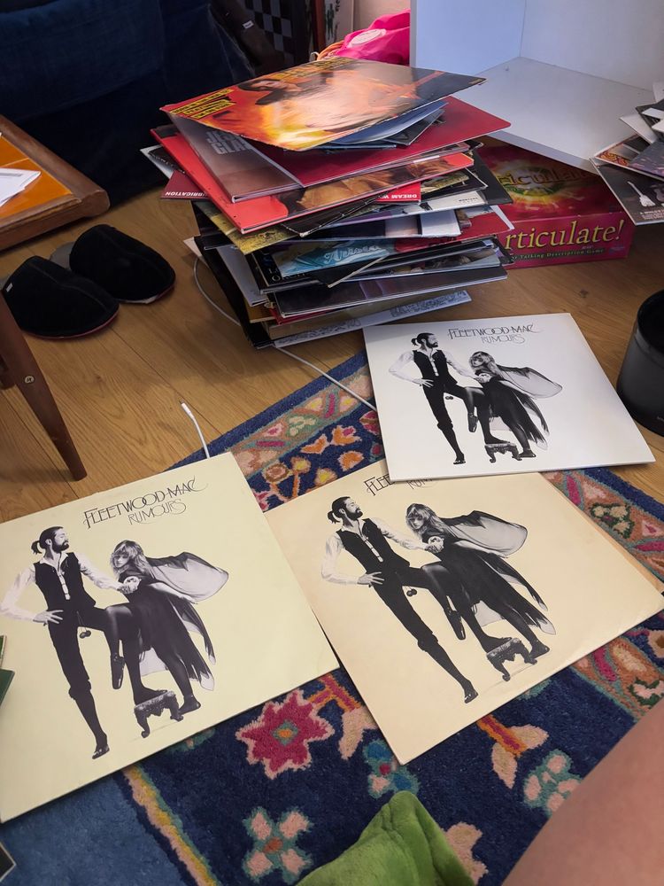 three copies of fleetwood mac’s rumours album on vinyl, amongst stacks of other records