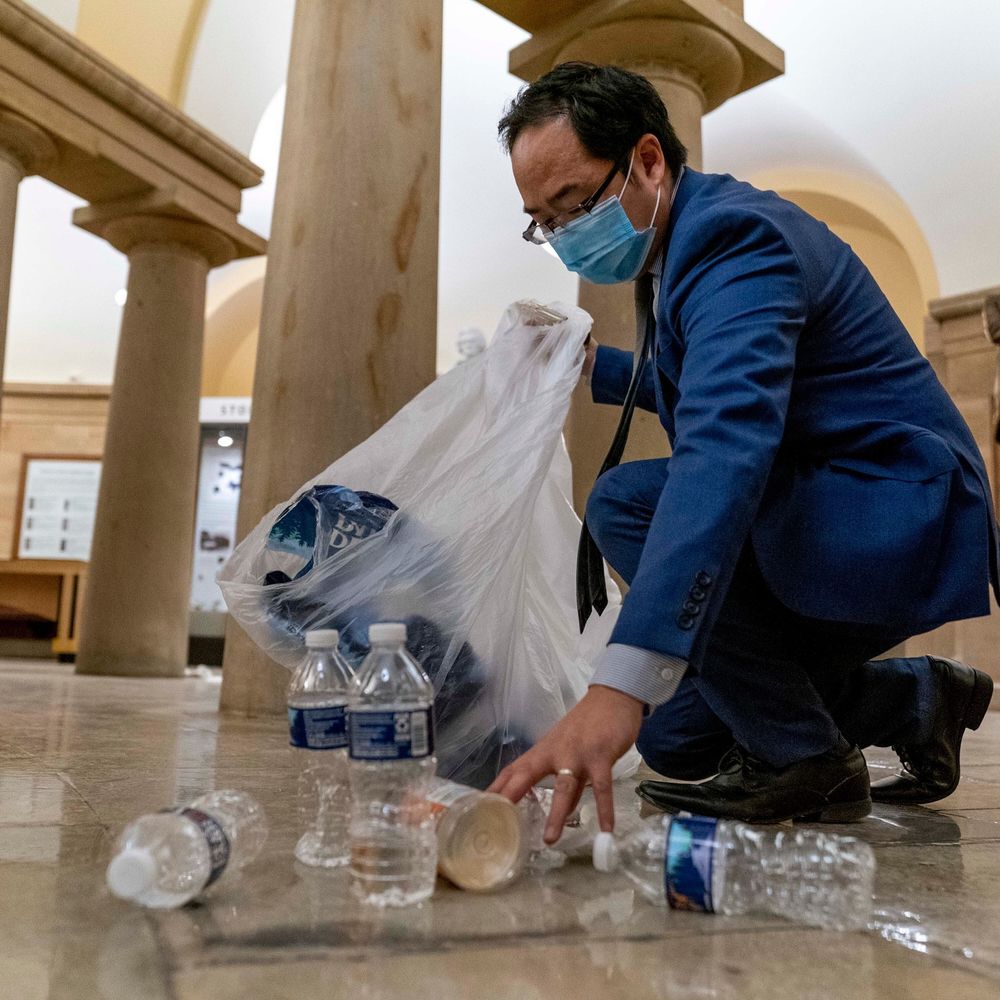 Is your man picking up garbage and putting it into a clear plastic garbage bag in a government building