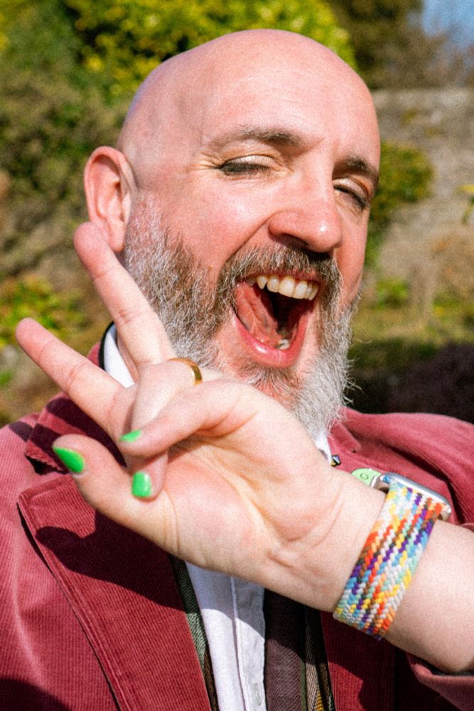 Selfie in warm sun in my garden. I’m doing a cheeky expression, throwing a ✌🏻 sign, and I’m wearing subtle but noticeable metallic eyeshadow, smudgy eyeliner and mascara