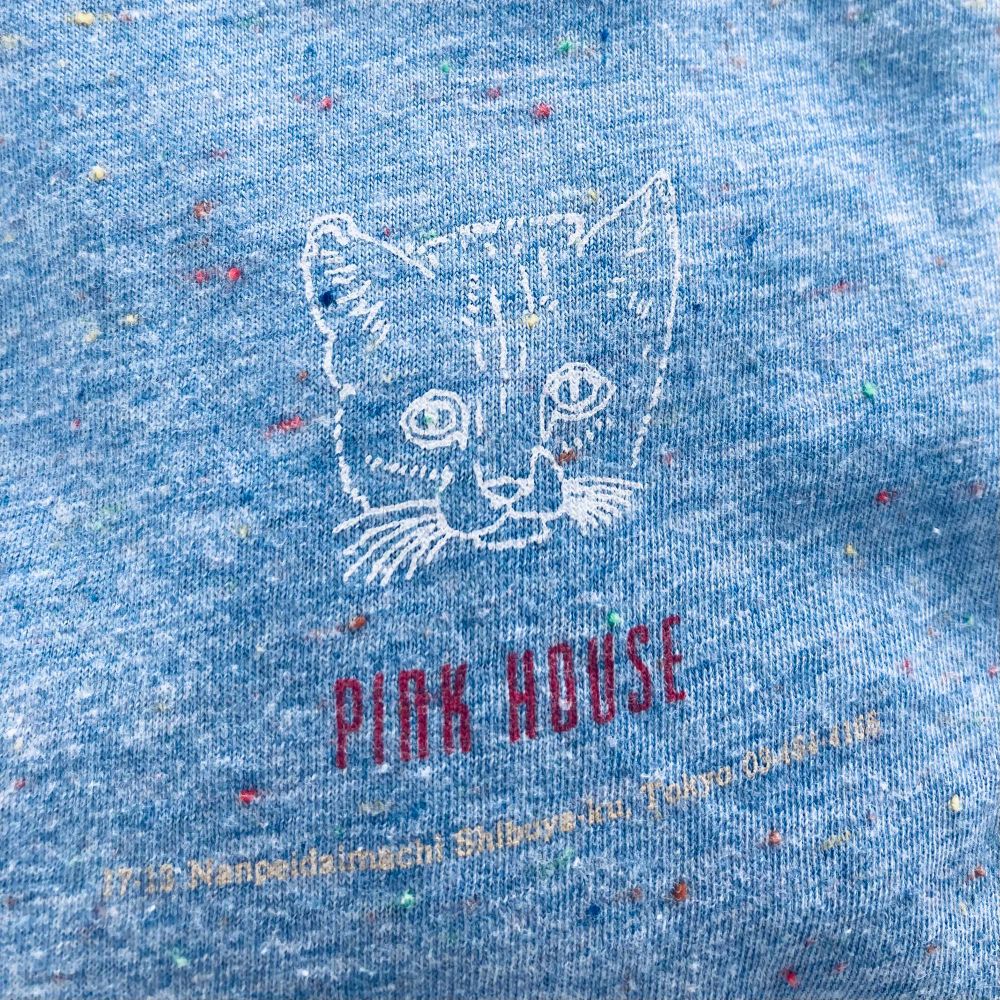 PINK HOUSEのＴシャツ。水色の生地に、白い線でやさしい目をしたねこの顔が描かれている