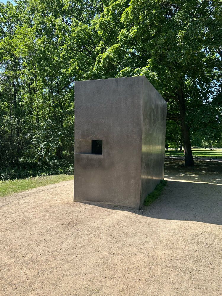 Photo of the Monument to Homosexuals Persecuted Under Nazism. A shiny stone installation that has a window which shows film honoring homosexuals who were criminalized and killed by nazis.