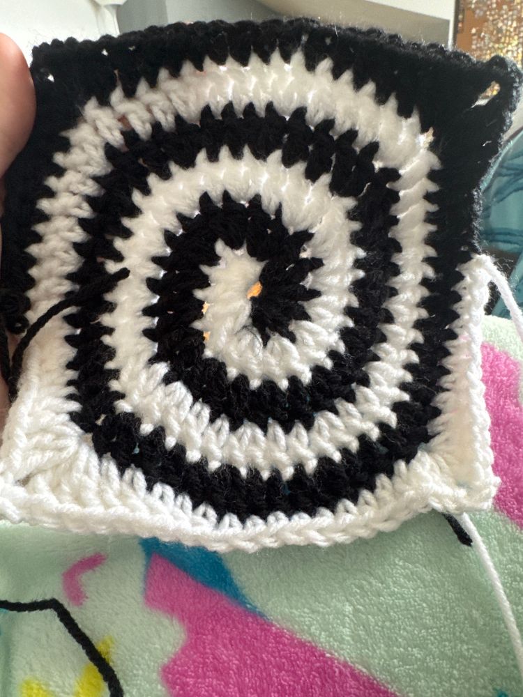 A picture of a crochet granny square in a black and white swirl 