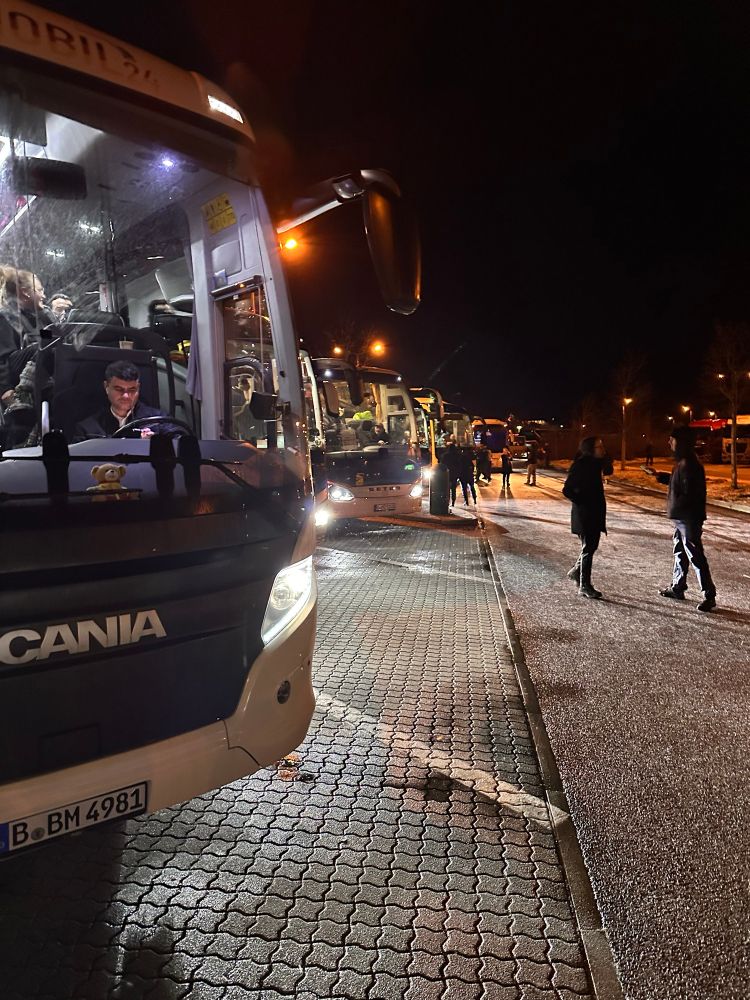 Busse auf einem Parkplatz bei Nacht.