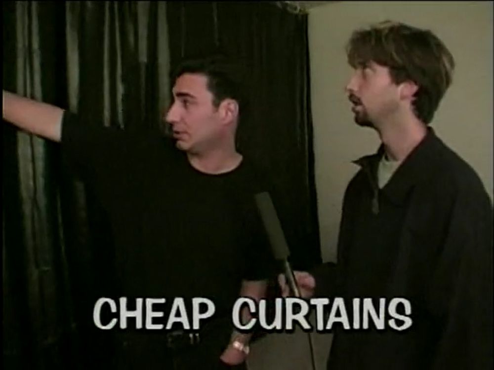 Phil and Tom looking at curtains, captioned Cheap Curtains