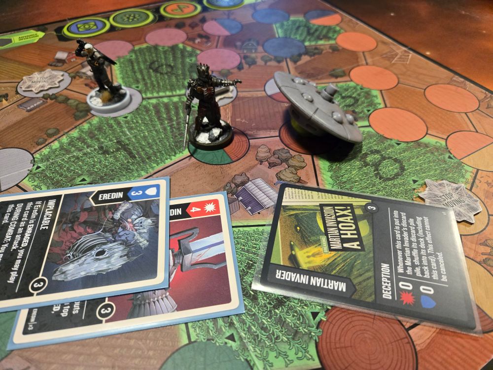 A game of Unmatched Adventures by Restoration at it's end state. Hand painted miniatures stand behind the cards that were played to end the game