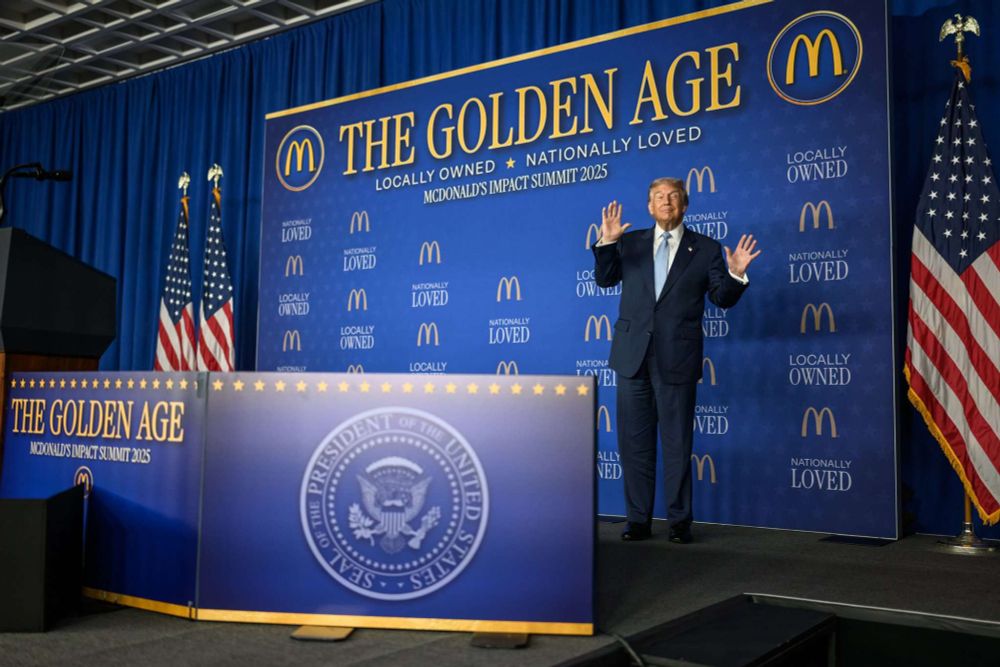 Donald Trump in front of blue McDonald's wall titled The Golden Age