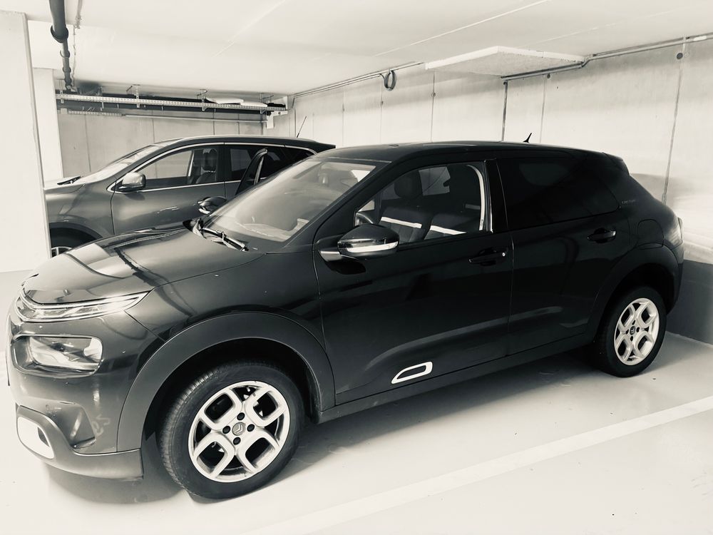 Ein schwarzer Citroën C4 Cactus in einer Tiefgarage, das Foto ist in schwarz-weiß 