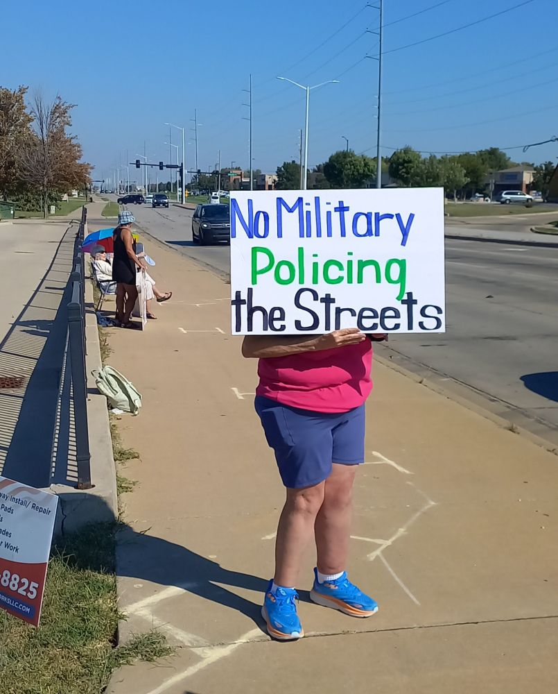Protester with sign saying No Military Policing the Streets.