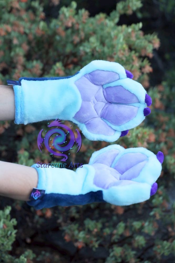A set of blue dragon fursuit paws with purple palms and claws.