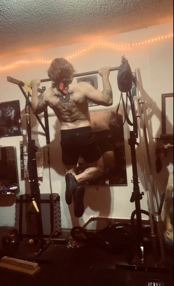 Old guy wearing a Rambo style headband doing pull-ups. 