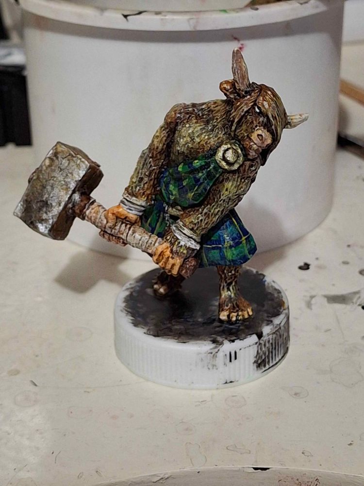 Highland cow Minotaur with big hammer and weird little man feet wearing blue, green and yellow kilt 