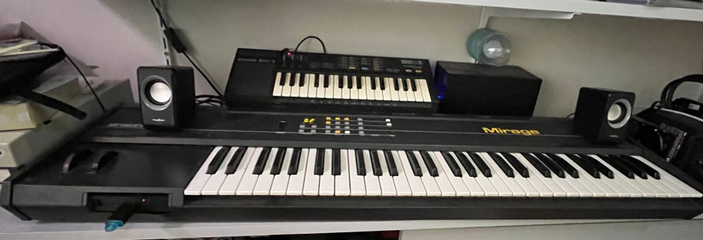 A Casio sk1 keyboard sits above an Ensoniq Mirage keyboard 