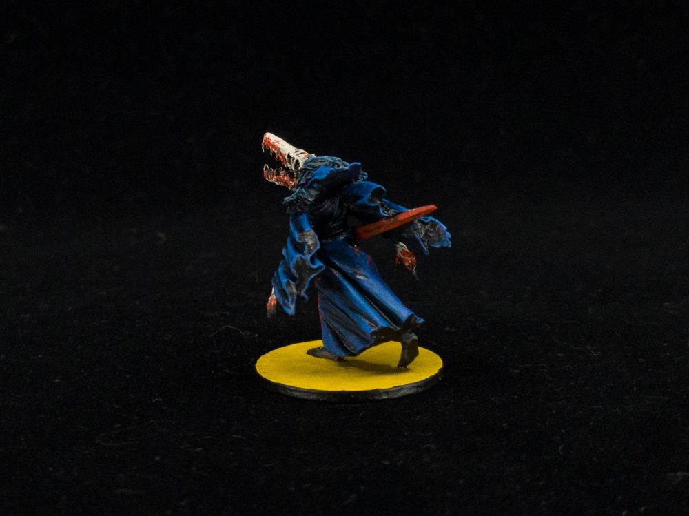 Rear angle of painted Mörk Borg mini showing robe and sword details.