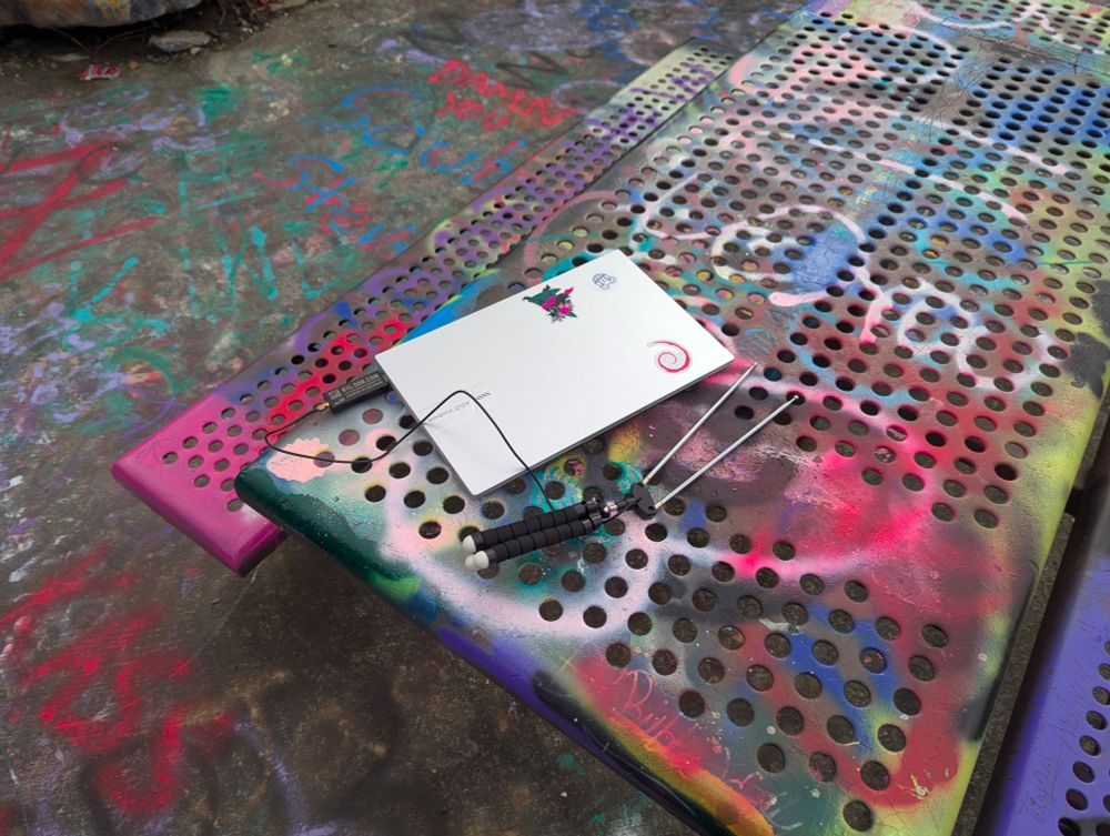 A photo of my laptop on a graffitied bench at dan's rock