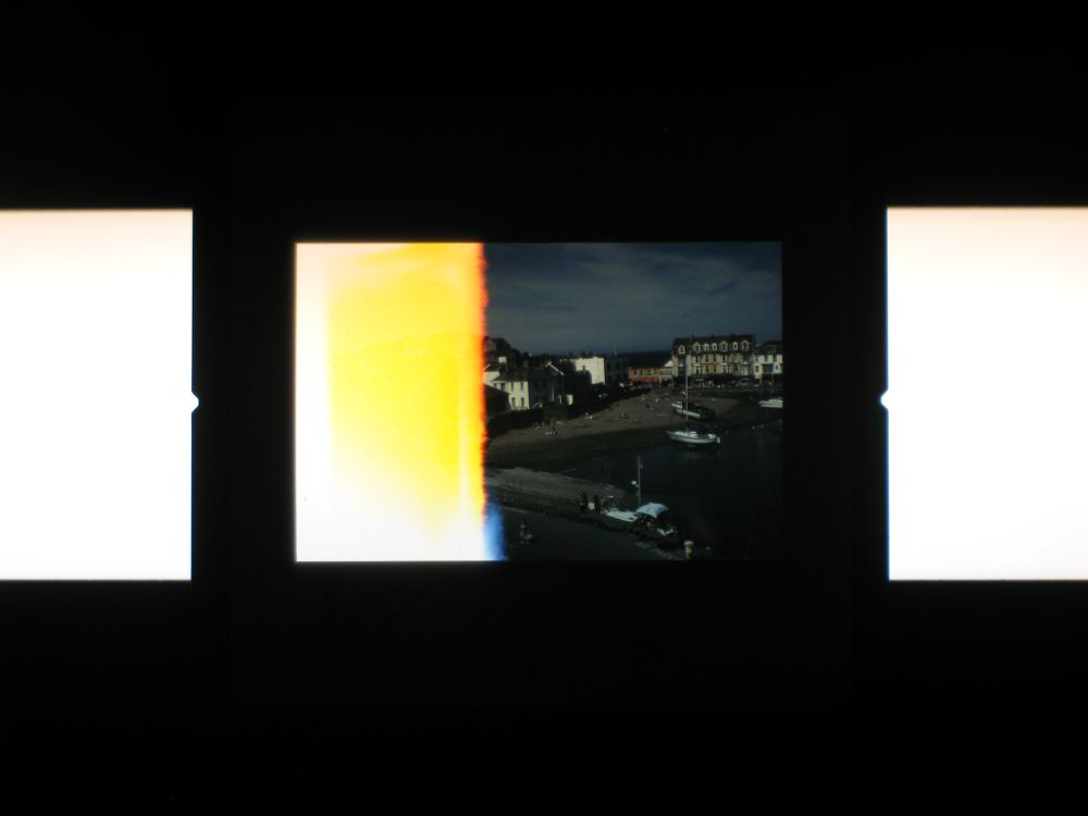 An improperly exposed Kodachrome slide of a seafront with the left side completely blown out