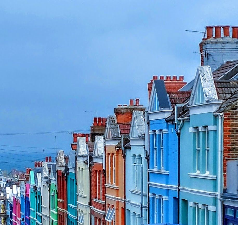 a colorful row of townhouses set against a deep blue sky
