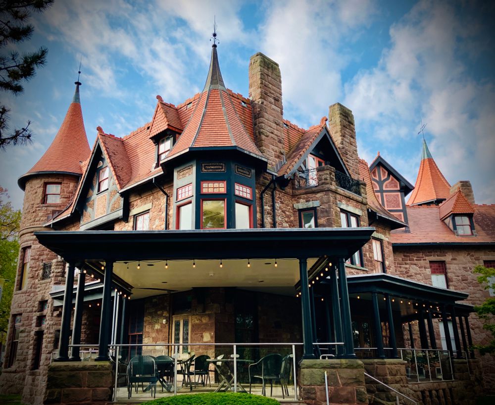A neo-gothic mansion-castle, with red cobblestones, and adorned with several spires. 