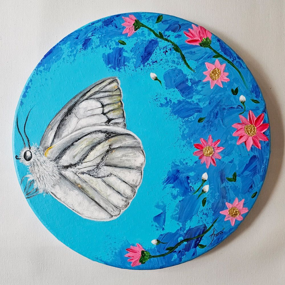 Blue, round painting of a moth surrounded by pink and gold flowers.
