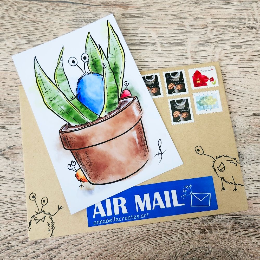 Postcard featuring a watercolor drawing of a snake plant in a brown clay pot. Three fantasy bugs are hiding in the leaves. The card is resting on a brown paper envelope with more bugs drawn on it and 5 stamps.