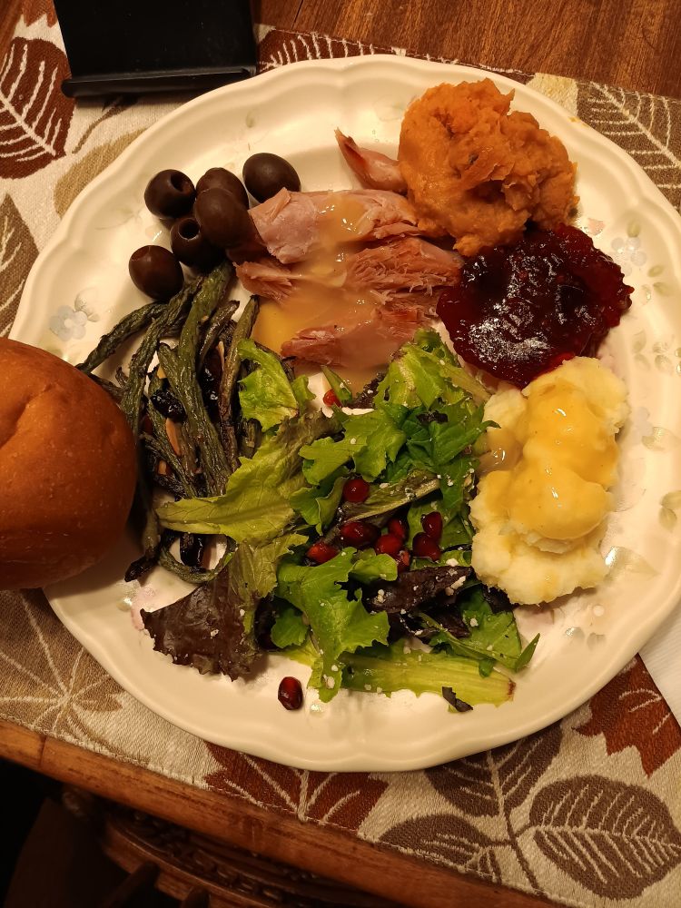 A dinner tonight was roasted green beans with cranberries and almonds, mashed potatoes and sweet potatoes, salad with pomegranate seeds, cranberry sauce, smoke turkey under gravy, olives, and a store bought roll.