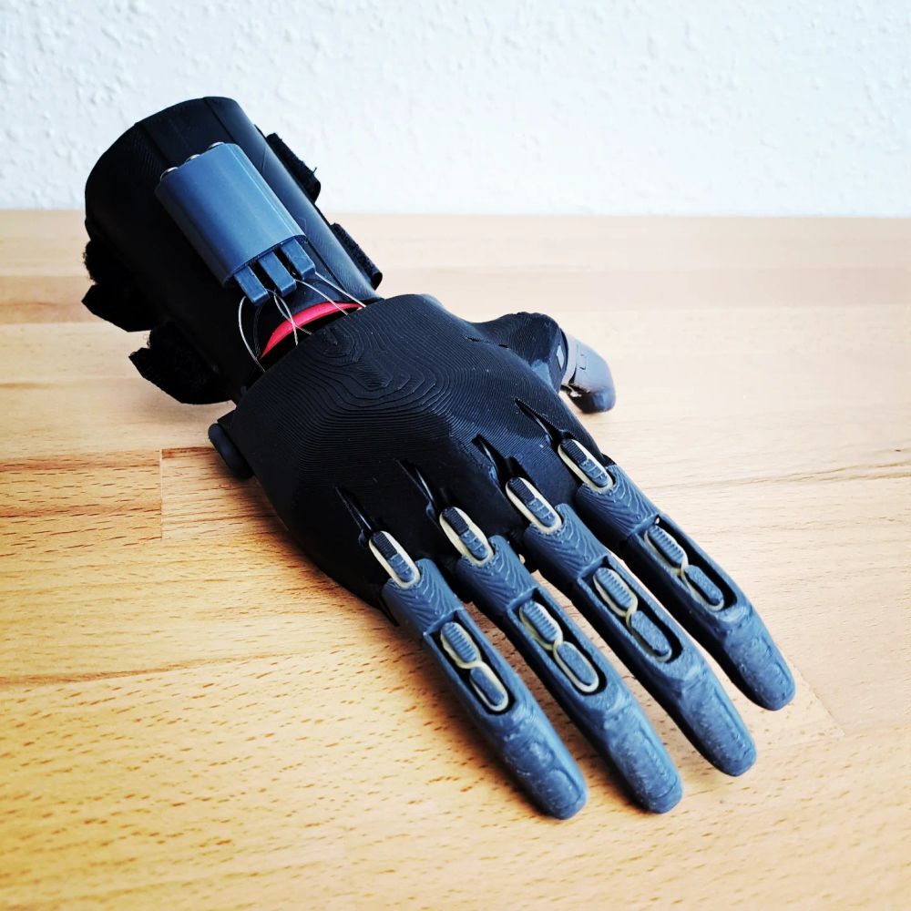 Main artificielle faite en impression 3D avec des élastiques et des fils en nylon pour articuler les doigts 