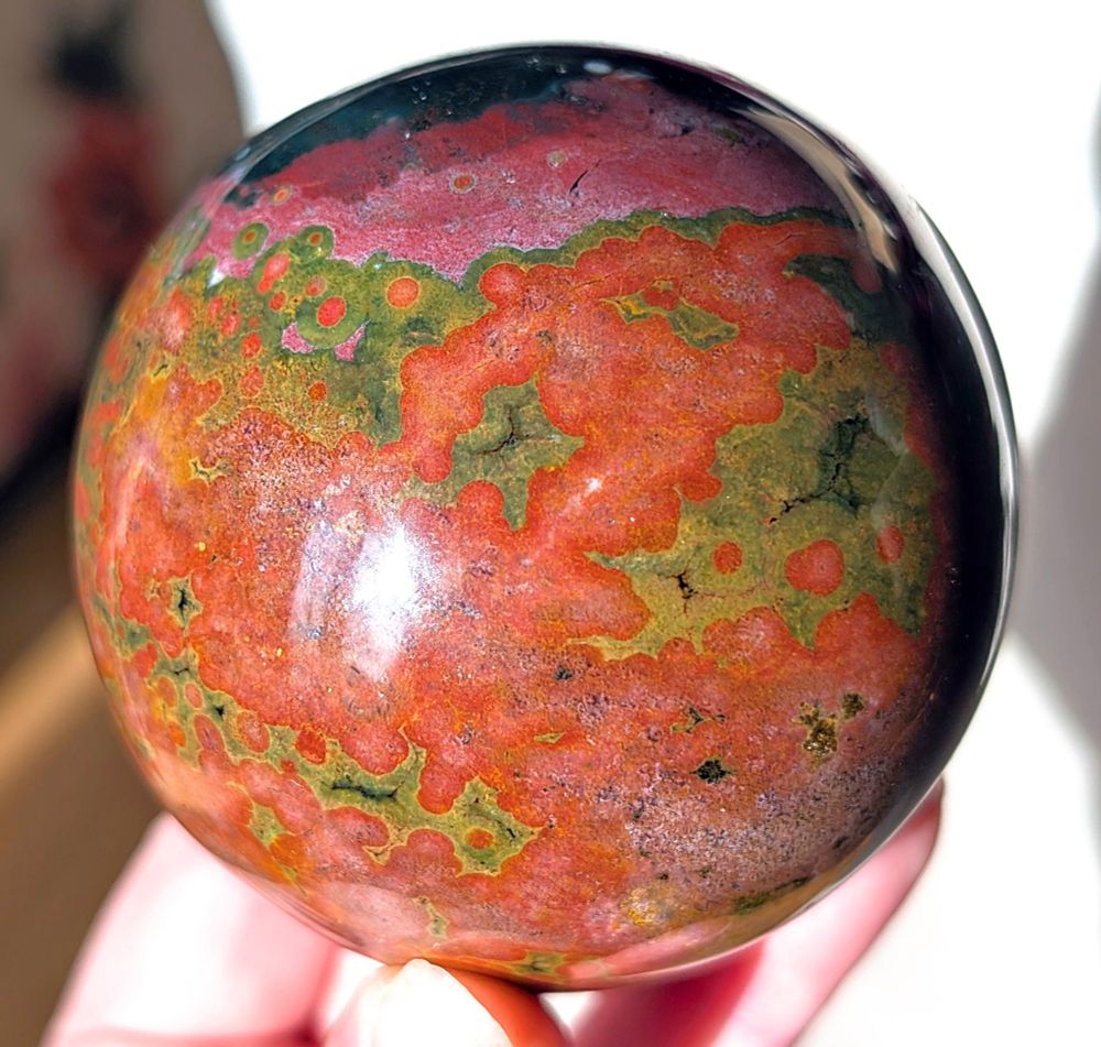 New sphere! I believe it is a variety of ocean jasper. "Ocean Jasper" is formed through the process of silicification, where other minerals are replaced by silica (primarily quartz), resulting in the formation of chalcedony. It primarily consists of silicified rhyolite and quartz. 


