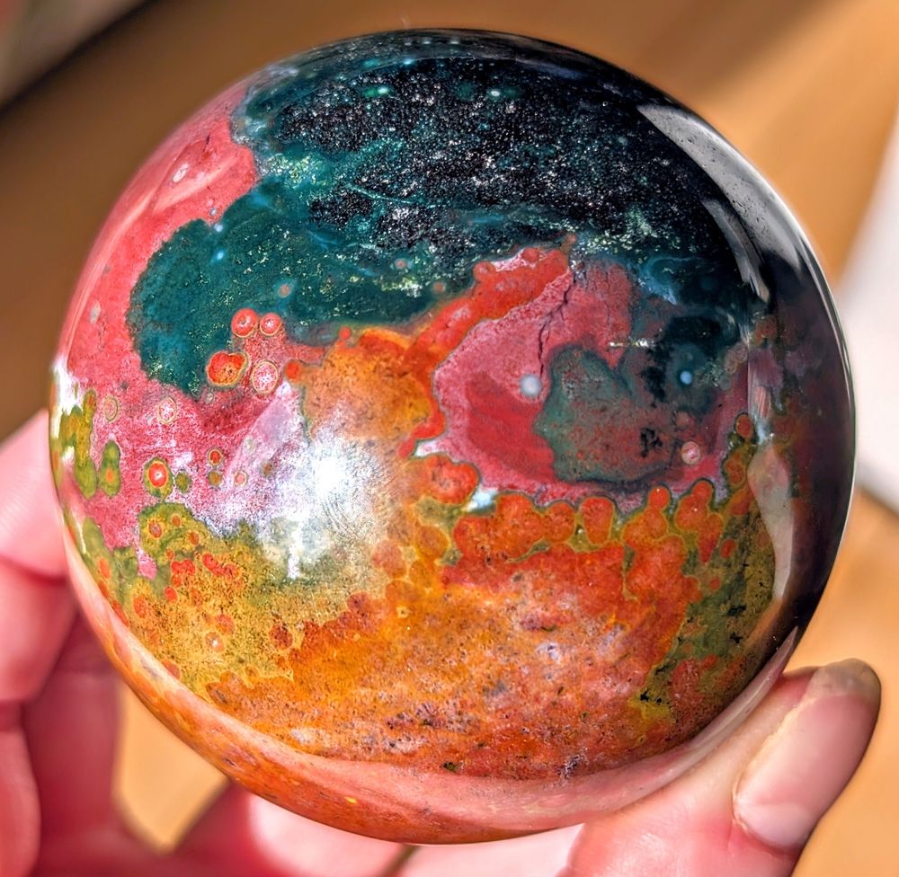 New sphere! I believe it is a variety of ocean jasper. "Ocean Jasper" is formed through the process of silicification, where other minerals are replaced by silica (primarily quartz), resulting in the formation of chalcedony. It primarily consists of silicified rhyolite and quartz. 

