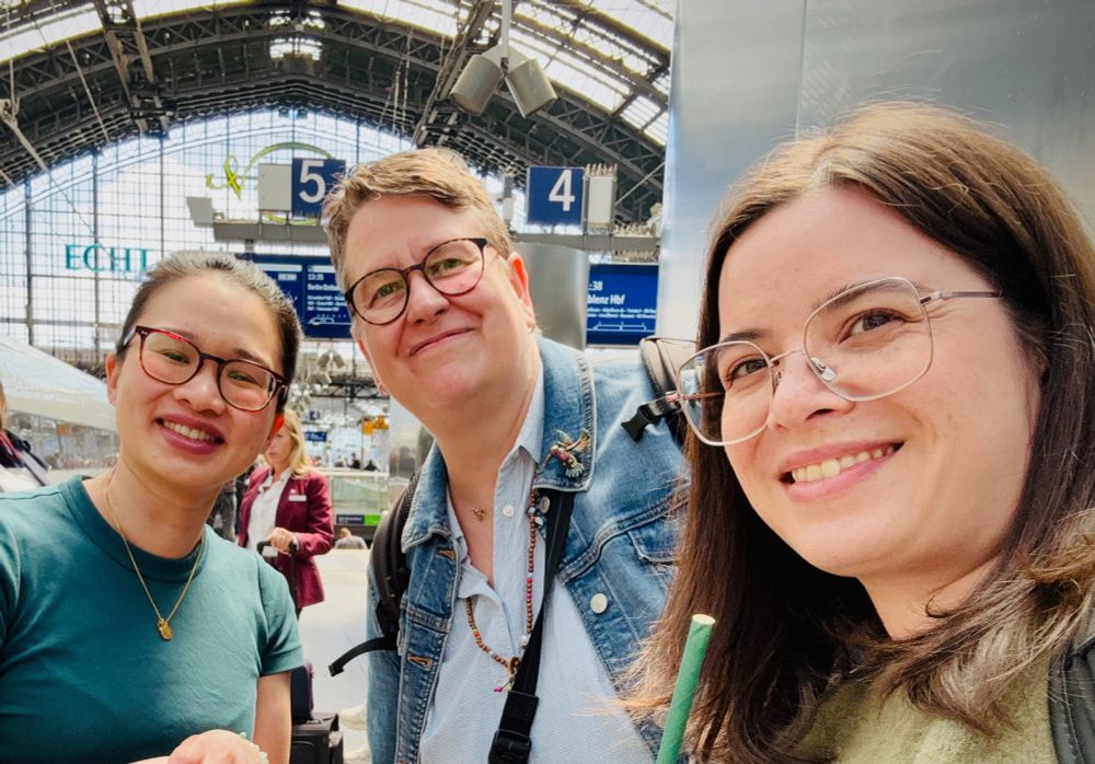 three people looking in the camera in a train station