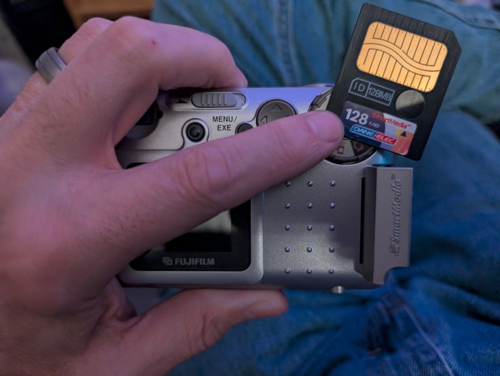 A 128 Megabyte Smartmedia card on top of a Fuji MX-1200 digital camera.