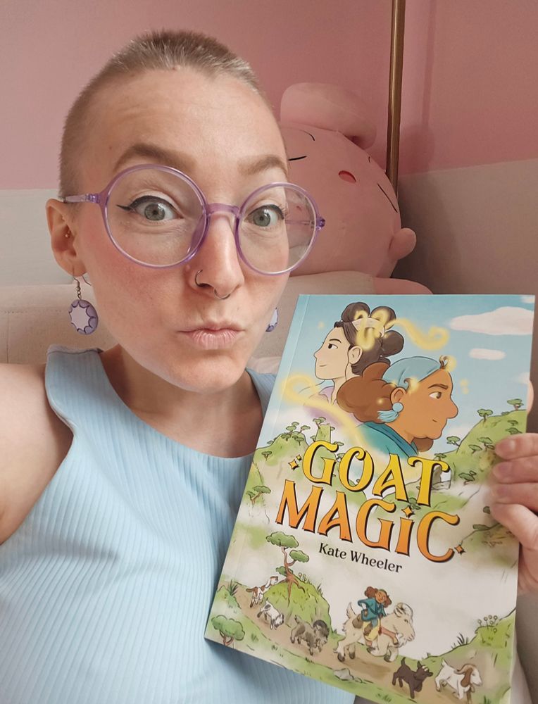 Comics letterer Haley Rose-Lyon holding a copy of Goat Magic by Kate Wheeler (Oni Press)