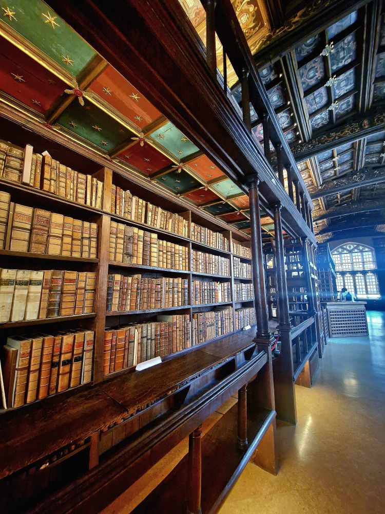 Old books on a wooden shelf. 