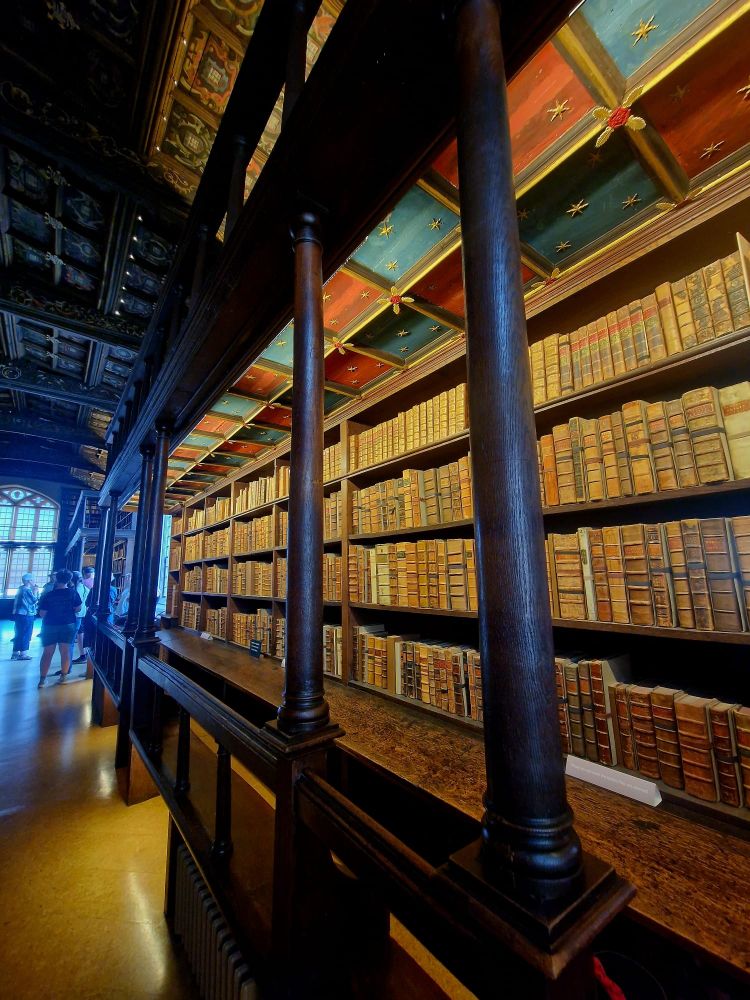 Old books on a wooden shelf. 