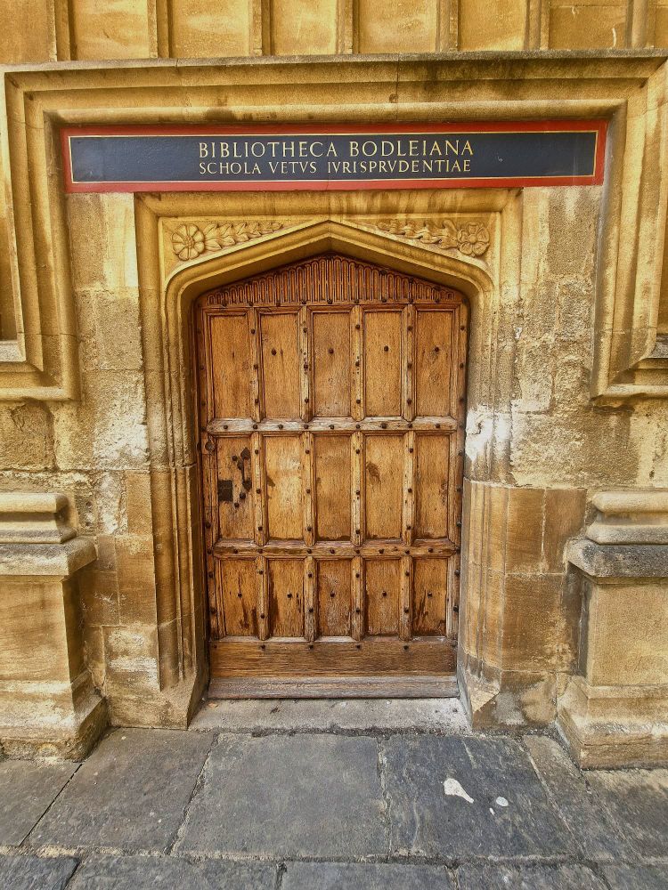 A wooden door with a sign in Latin.