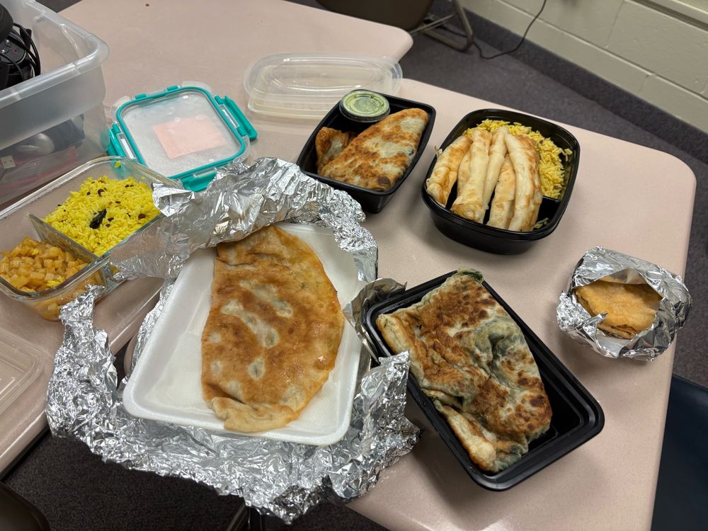Foods my students shared with me for lunch, all made by their families: Indian potatoes and lemon rice, 3 types of Afghan bolani, Turkish börek, Afghan chicken biryani, and Venezuelan chicken arepa!