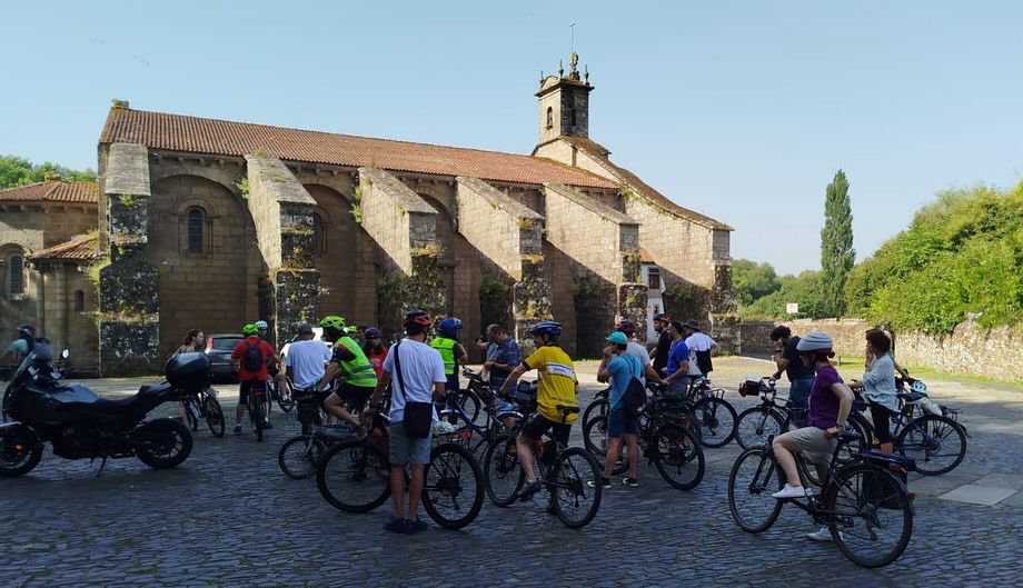O grupo de participantes na pedalada ao lado da Colexiata do Sar