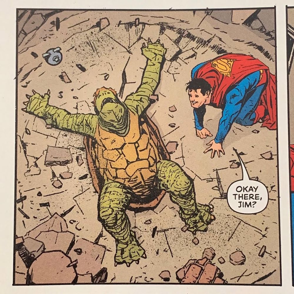 Jimmy Olsen, transformed into a Turtle Boy due to shenanigans, is flat on his back at the center of an impact crater after falling from orbit and destroying a newly built Metropolis monument. Superman is next to him, smiling but mussed up and on all fours, asking "Okay there, Jim?"