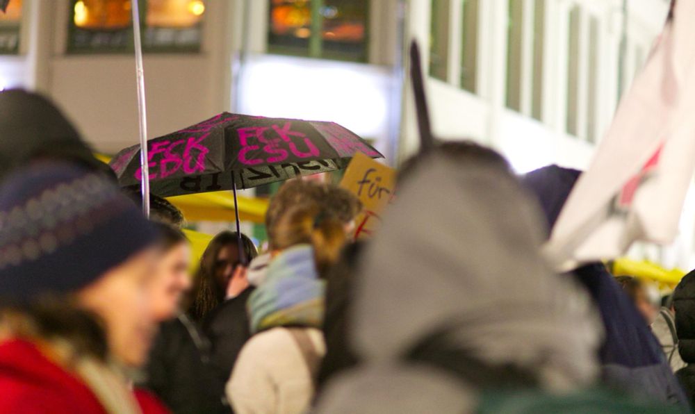 Bild 3: in einer Menschenansammlung auf der Demo ist ein schwarzer Regenschirm mit pinker Schrift: "FCK CDU" rundum zu sehen.