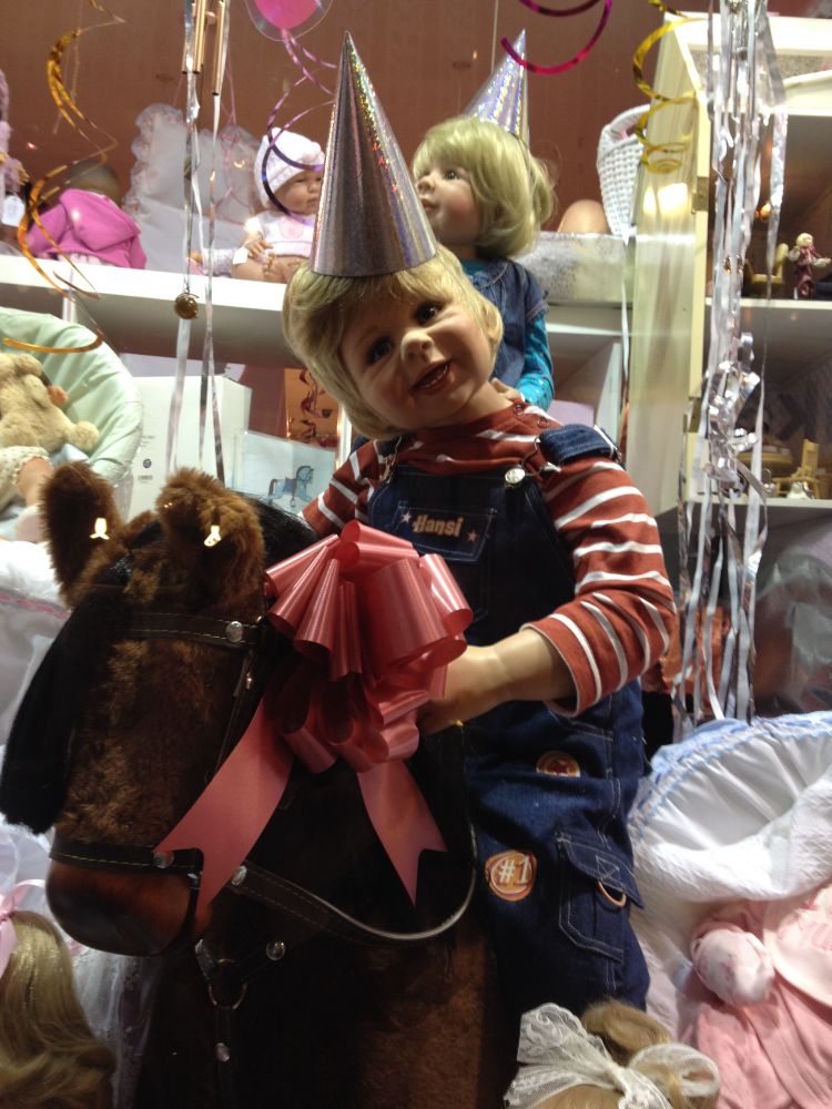 a creepy toddler doll riding a stuffed donkey