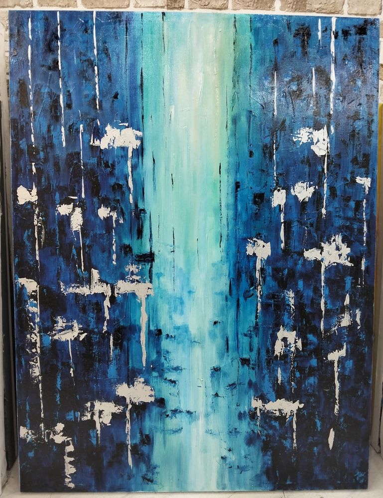 an abstract painting, it is blue, a light blue and white beam of light coming through the middle, small dabs and drips of white paint on the left and right sides 
