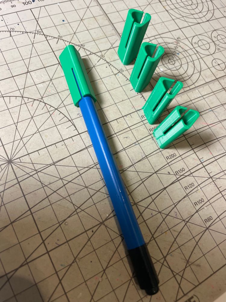 blue digital stylus with a green cap next to 4 more green caps representing previous designs