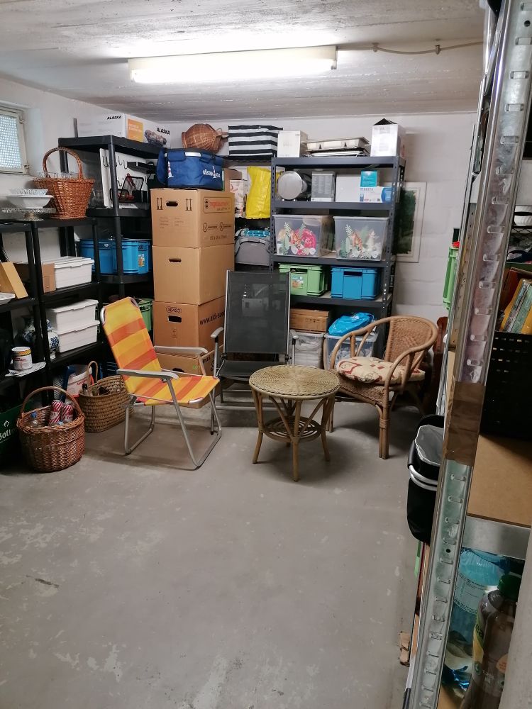 Nachher: Gleicher Kellerraum, aber aufgeräumt. In der Mitte steht jetzt ein Korbtisch und drum herum drei Stühle.