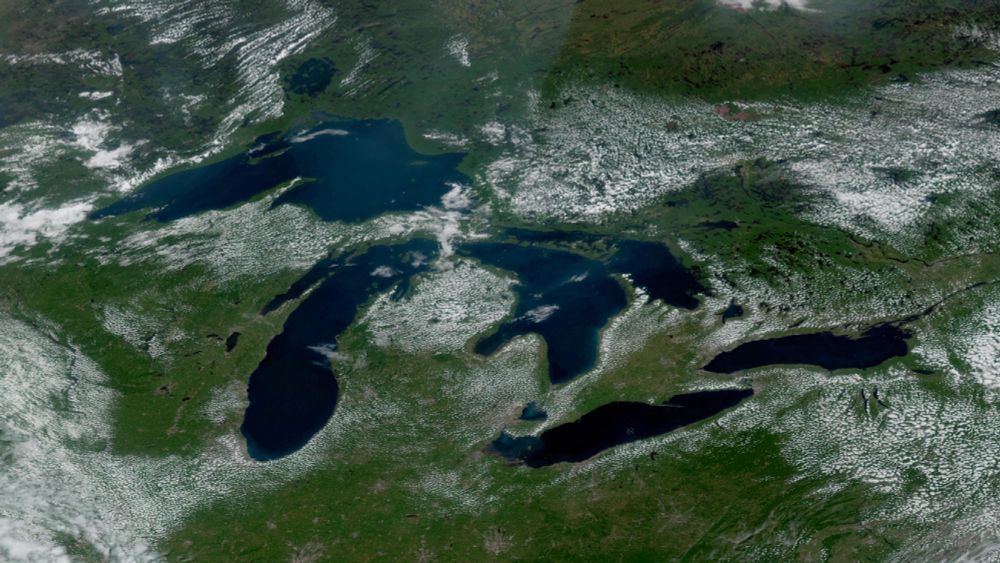 A visible satellite image of the Great Lakes on Sunday afternoon. Puffy cumulus clouds neatly outline the shores of most of the lakes.