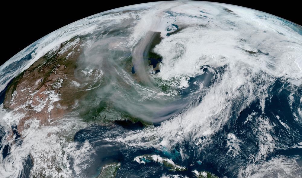 A visible satellite image of North America on Saturday afternoon, showing thick plumes of smoke across Canada and the U.S.