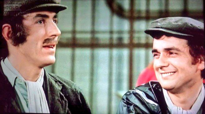 Pete and Dud sitting talking about Cleopatra's travelling arrangements.