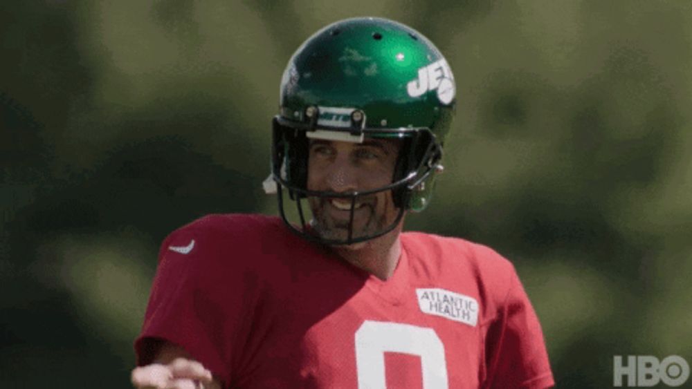 a football player wearing a green helmet and a red shirt with the number 9 on it